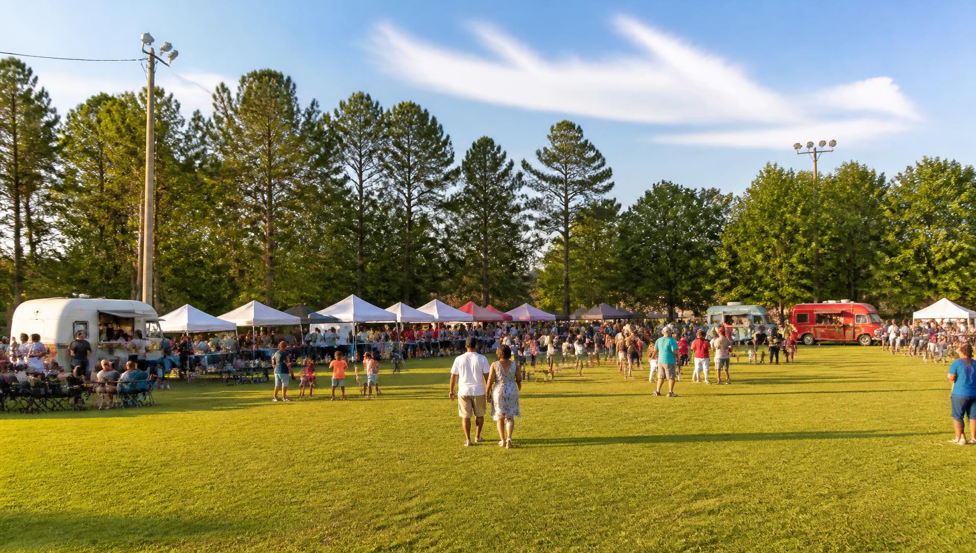Families gather among food trucks and live music at a Southern food festival